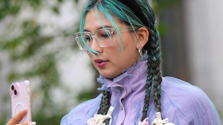 Woman wearing lavender jacket and glasses