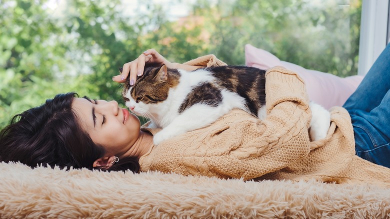 person laying with cat on chest