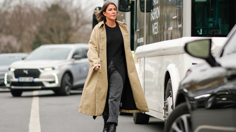 Woman wearing gray jeans, trench