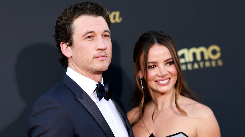 Miles Teller and Keleigh Sperry posing together on a red carpet.