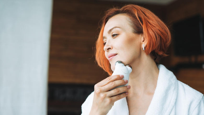 Woman using NuFace microcurrent device