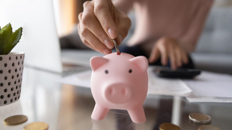 Putting coin in piggy bank