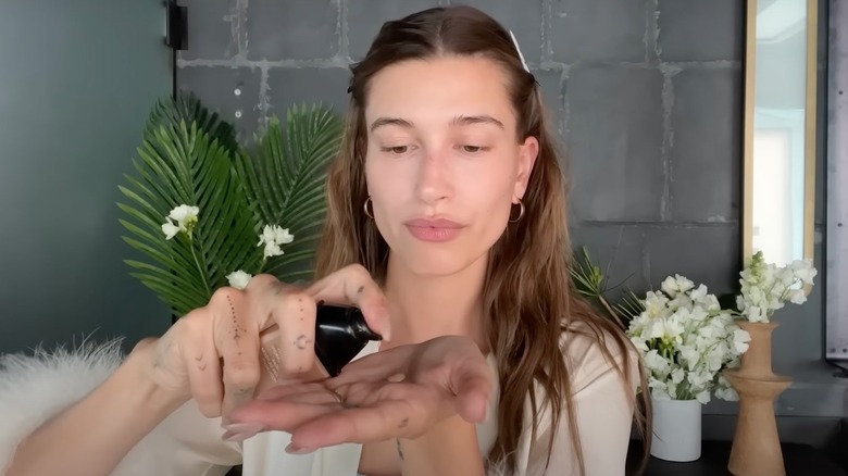 Hailey Bieber pumping foundation into hand