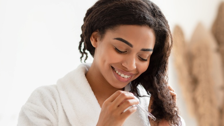 Woman using serum on hair