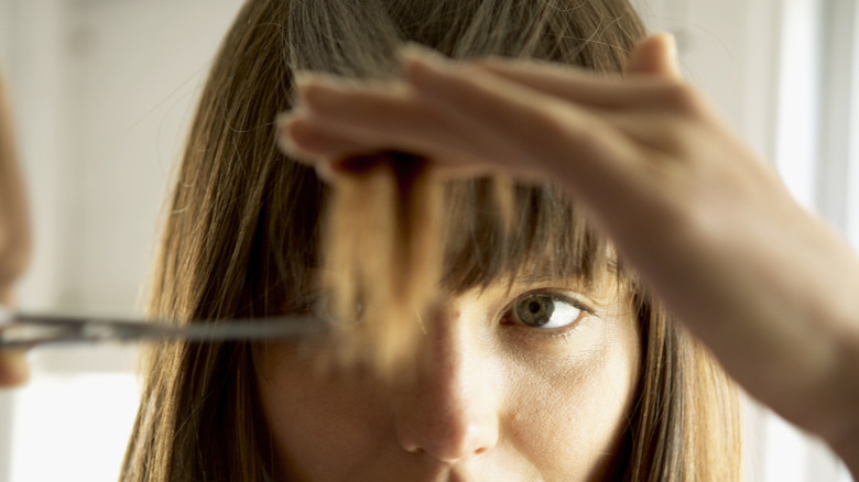 Woman cutting her bangs