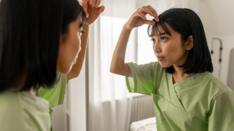 A woman styling her bangs