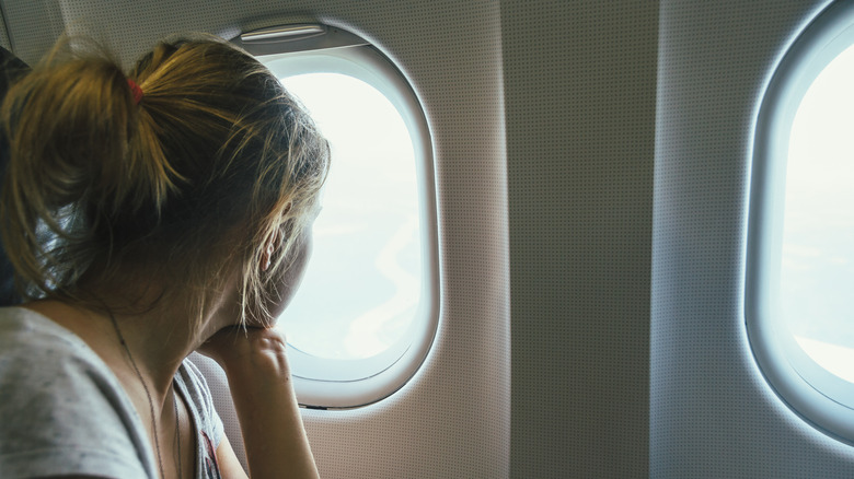 woman looking out of plane window