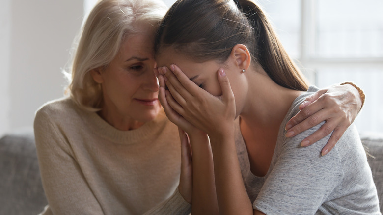 woman comforting friend on couch