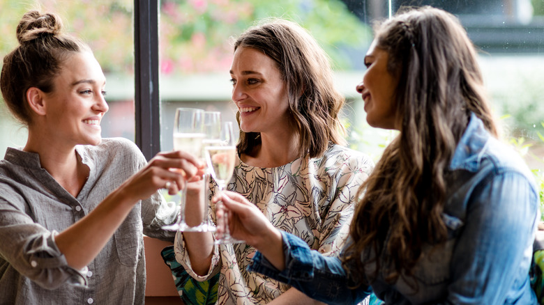 Three girls drinking wine together