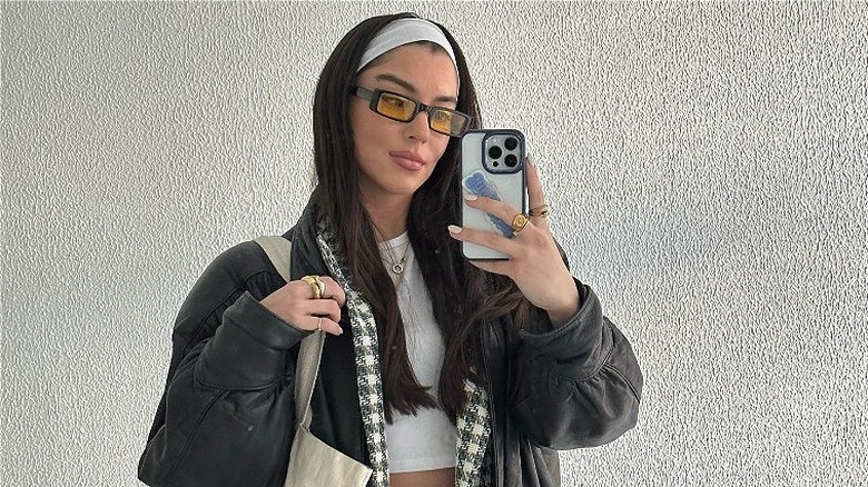 woman with headband taking photo