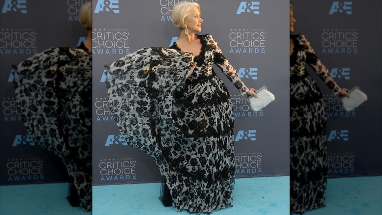Helen Mirren posing at a red carpet event in 2016 wearing a flowy black and white gown.
