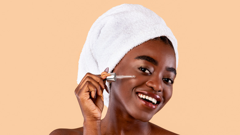 woman using retinol on face