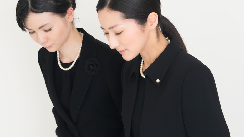 female funeral attendees in black outfits