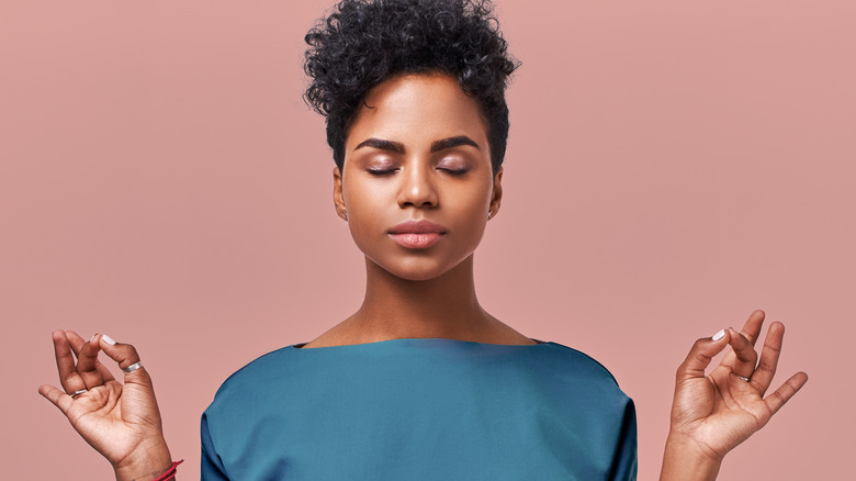 A woman meditates with her eyes closed