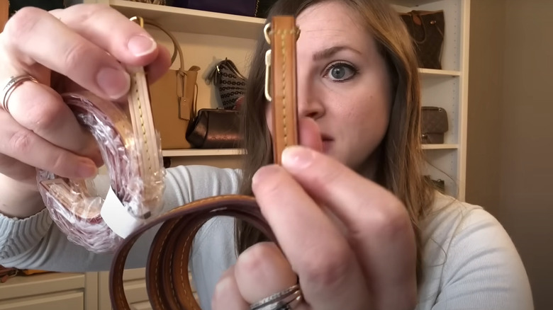 Mama Beech holding two LV straps, one fake one real