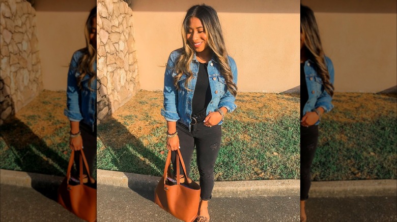 Girl wearing black jeans with a denim jacket.