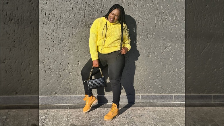 Woman wearing black skinny jeans with a sweater.