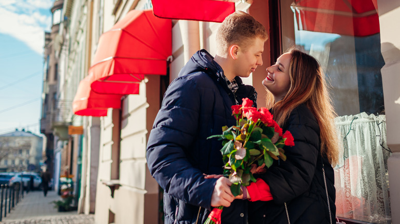Couple on sidewalk with roses
