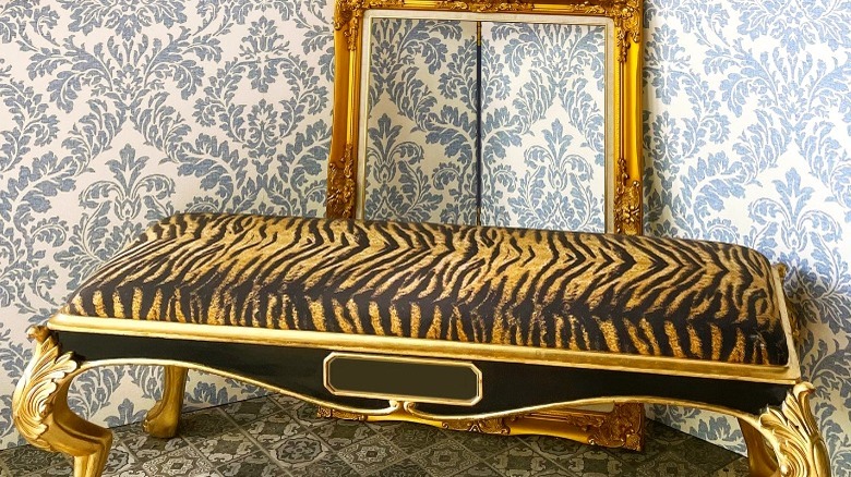 Tiger-striped divan against floral wallpaper