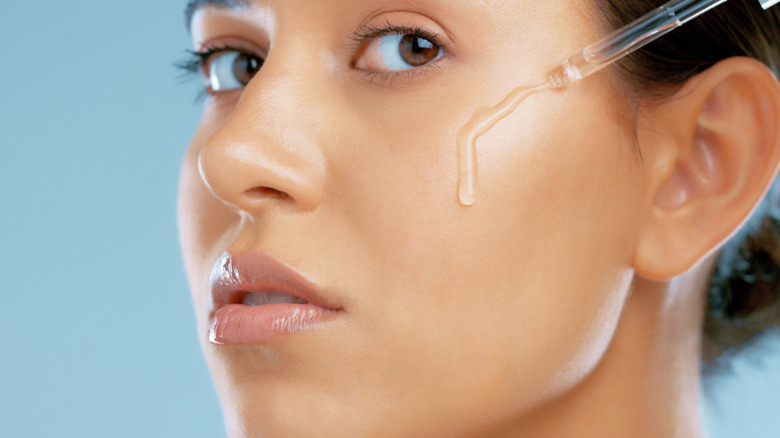 Woman using skincare serum 