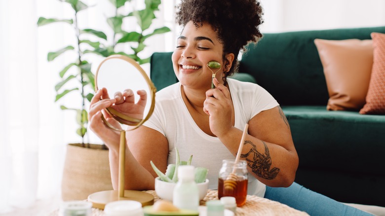Woman using a jade roller on her face 