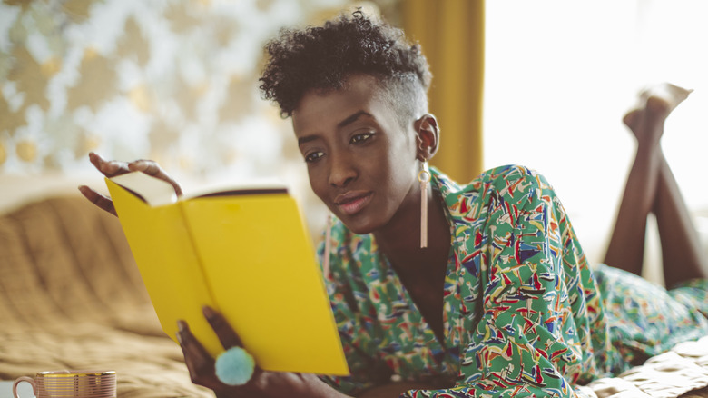 Woman reading book on bed