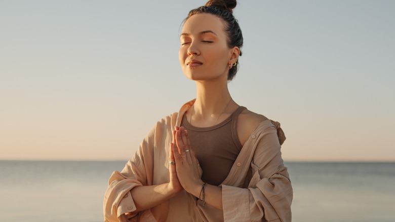 woman meditating by ocean