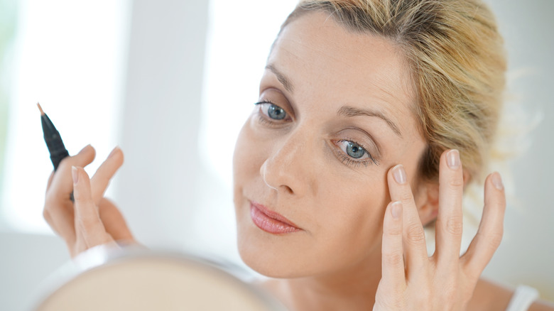 Woman putting on concealer