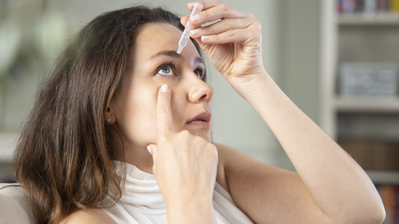Woman putting in eye drops