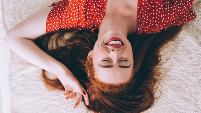 happy woman alone in bed