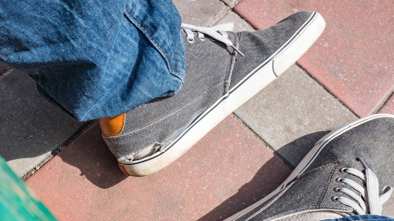 person with torn sneakers