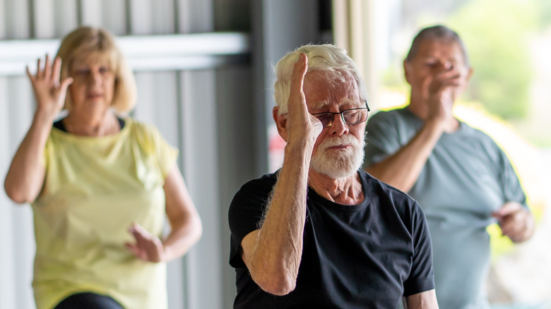 three people doing tai chi