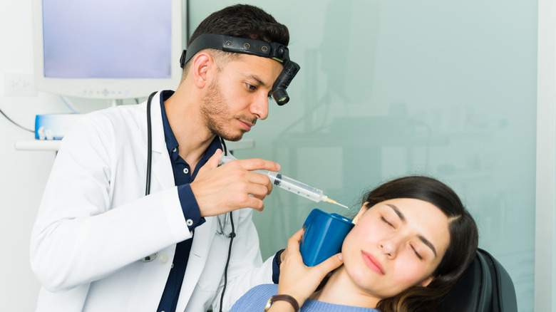 ENT specialist cleaning patient's ear
