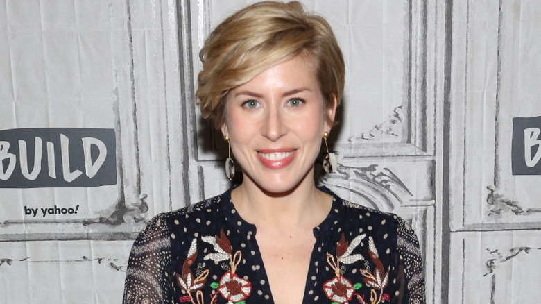 Erin Napier wearing a floral black-and-white outfit while smiling