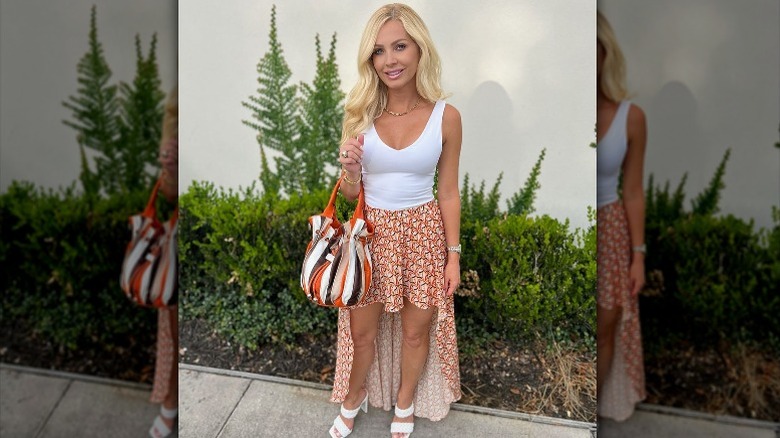 Blond wearing orange high-low skirt
