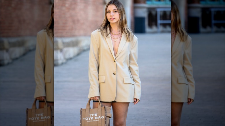 Woman wearing tan blazer and hot pants
