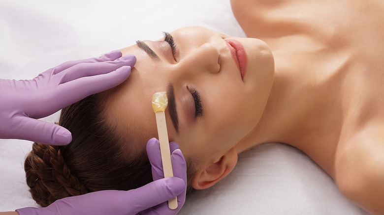 woman getting eyebrows waxed
