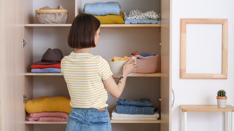 woman organizing clothes in closet