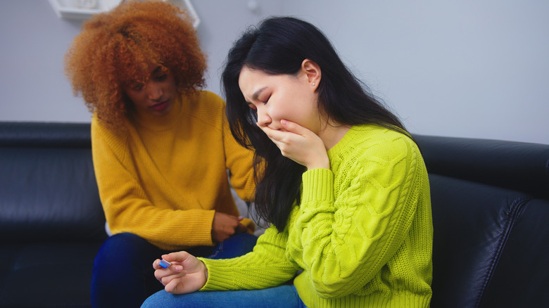 queer couple looking at a pregnancy test, upset
