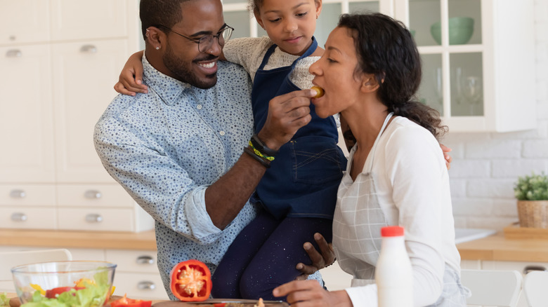 man feeding woman in kitchen