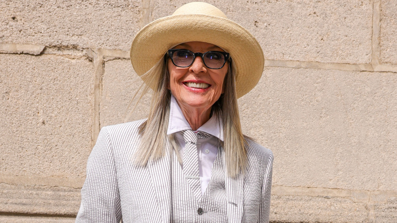 Diane Keaton posing in a stylish pinstripe pantsuit