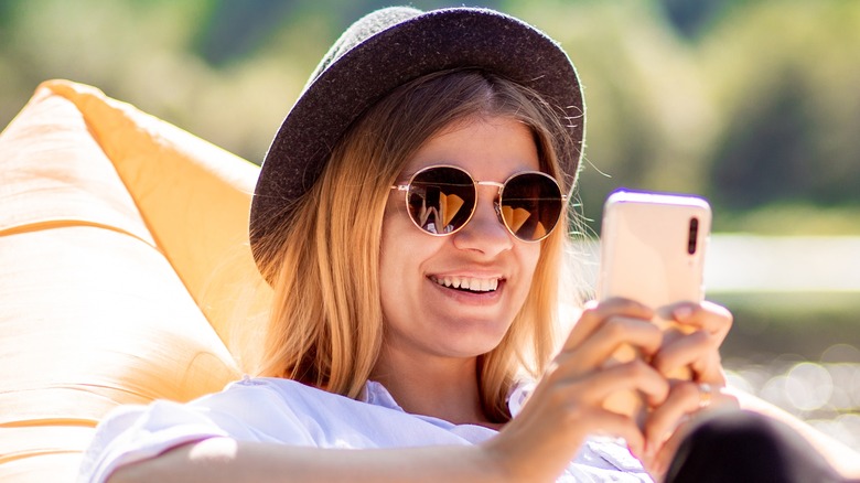 female blonde wearing a hat sitting in the sun