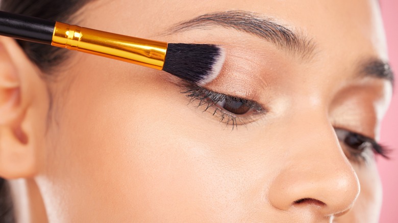 brush sweeping across eyelid makeup