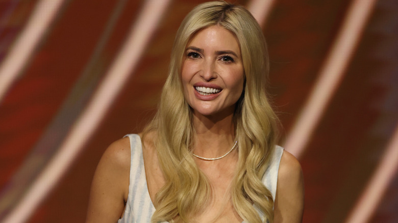 Ivanka Trump smiling in a white sleeveless dress