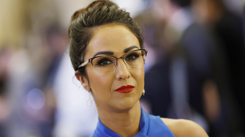 Lauren Boebert during a political meeting wearing a blue dress with her pulled up