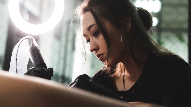 Female tattoo artist concentrating