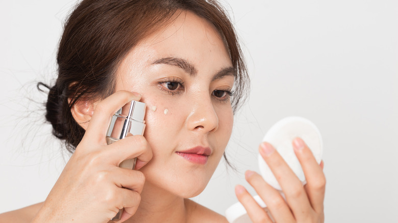 A woman applying liquid foundation