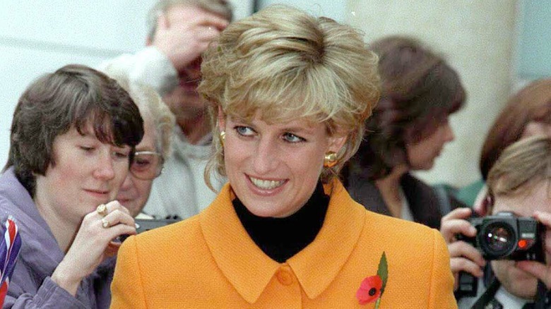 Princess Diana smiling in a yellow Versace suit