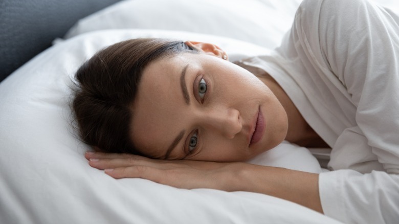 Stressed woman lying in bed