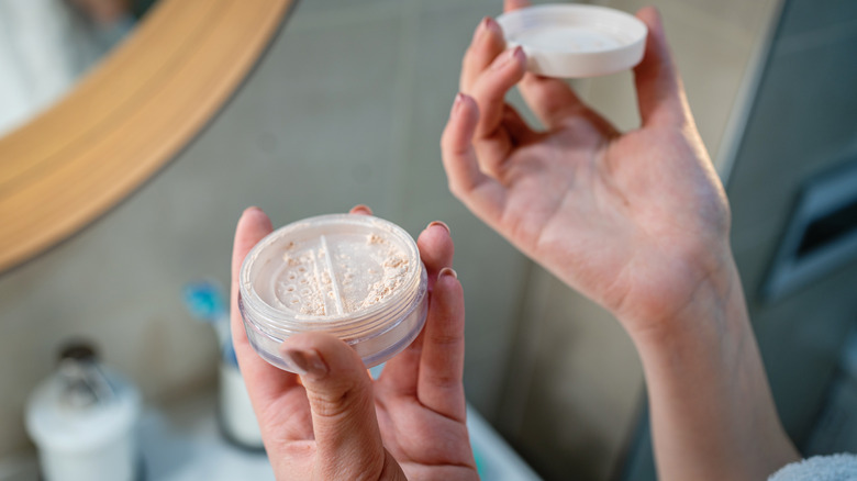 woman holding loose setting powder